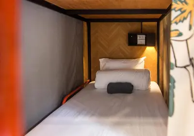 a small bed in a small room with a pillow at TAN Hostel x Cafe , Aonang Beach in Ao Nang Beach