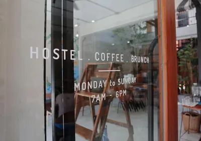 a window of a coffee shop with a table and chairs at TAN Hostel x Cafe , Aonang Beach in Ao Nang Beach
