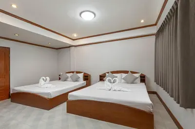 a bedroom with two beds with white sheets at Break Point Patong Hotel in Patong Beach