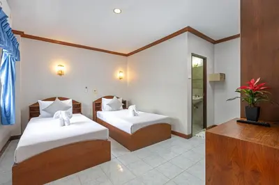 a hotel room with two beds and a television at Break Point Patong Hotel in Patong Beach