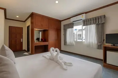 a bedroom with a bed with two white towels on it at Break Point Patong Hotel in Patong Beach