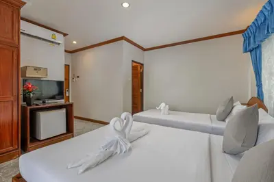 two beds in a room with a tv at Break Point Patong Hotel in Patong Beach