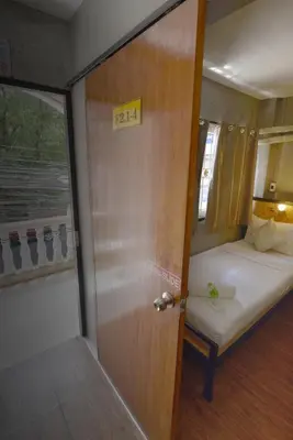 a door leading to a room with a bed and a door at OK CHIC PHUKET HOSTEL in Phuket Town