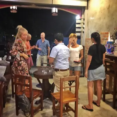 a group of people standing around a table at OK CHIC PHUKET HOSTEL in Phuket Town