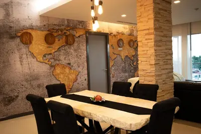 a dining room with a table and a wall with a map at Sunset Bliss in Klong Muang Beach