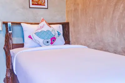 two beds with a pillow with a camera on it at Baan Tubkaek Hotel in Tab Kaek Beach