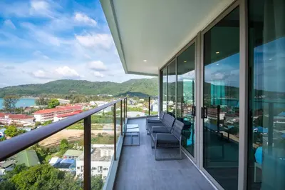 a balcony with chairs and a view of a city at Oceana Sea View Apartments - Kamala Beach in Kamala Beach