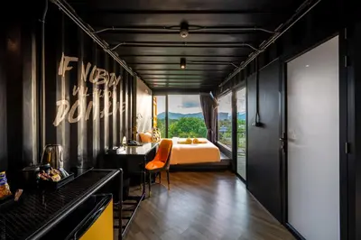 a bedroom with a bed and a bedroom with a view at Hivetel Phuket in Chalong