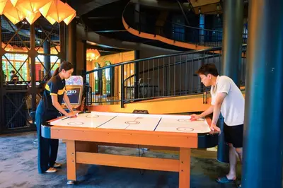 two people standing around a ping pong table at Hivetel Phuket in Chalong