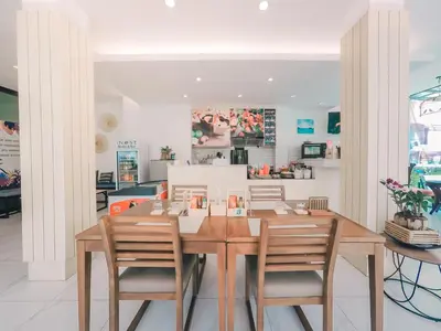 a dining room with a wooden table and chairs at iNest Poshtel in Kata Beach