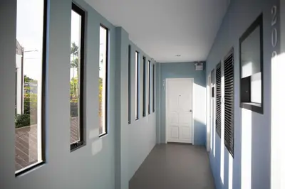 a hallway with blue and white walls and windows at iNest Poshtel in Kata Beach