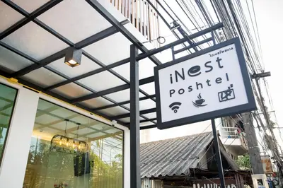 a sign in front of a store with a nestrequired sign at iNest Poshtel in Kata Beach