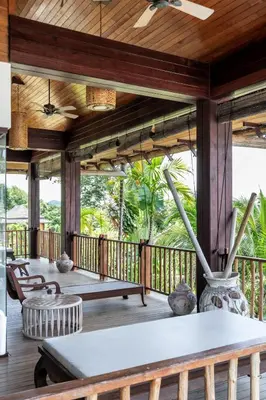 a porch with a table and chairs on a deck at Cho Fah Residence in Ko Yao Noi
