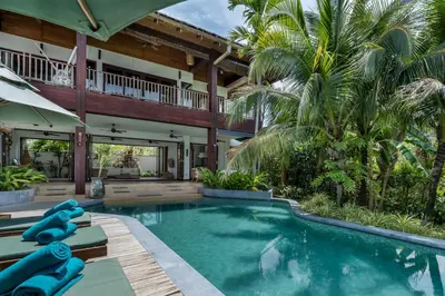 an indoor pool in a house with palm trees at Cho Fah Residence in Ko Yao Noi