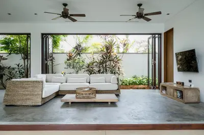 a living room with a white couch and a table at Cho Fah Residence in Ko Yao Noi