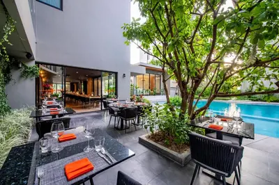 a restaurant with tables and chairs and a pool at Diamond Condominium Bangtao Beach in Bang Tao Beach