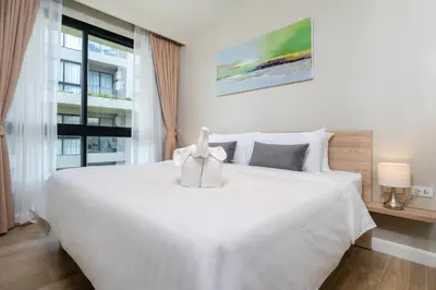 a bedroom with a large white bed and a window at Diamond Condominium Bangtao Beach in Bang Tao Beach