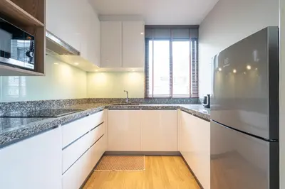 a kitchen with white cabinets and a refrigerator at Diamond Condominium Bangtao Beach in Bang Tao Beach