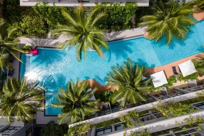 an overhead view of a resort swimming pool with palm trees at Diamond Condominium Bangtao Beach in Bang Tao Beach