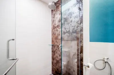 a shower with a glass door in a bathroom at The Pago Design Hotel Phuket-SHA Plus in Phuket Town