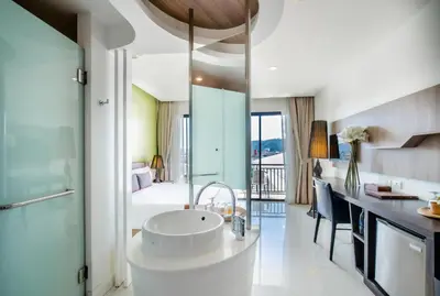 a bathroom with a sink and a room with a bed at The Pago Design Hotel Phuket-SHA Plus in Phuket Town