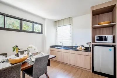 a kitchen and dining room with a table and a microwave at The Pago Design Hotel Phuket-SHA Plus in Phuket Town