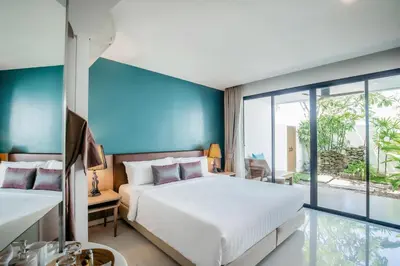 a bedroom with two beds and a large window at The Pago Design Hotel Phuket-SHA Plus in Phuket Town