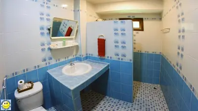a blue and white bathroom with a sink and a toilet at D&K Smiley Phuket Resort in Rawai Beach