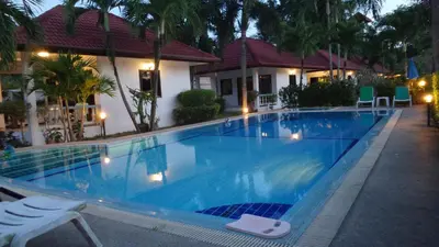 a swimming pool in front of a house at D&K Smiley Phuket Resort in Rawai Beach