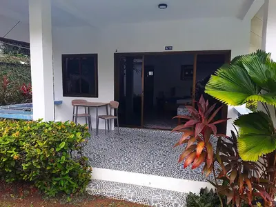 an open door of a house with a table and chairs at D&K Smiley Phuket Resort in Rawai Beach
