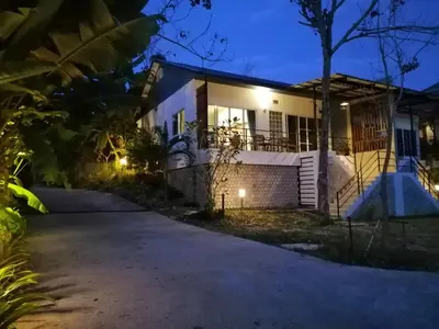 a house with a driveway at night at Twin Villa in Ban Muang Mai