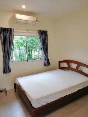 a bedroom with a bed and a window at Twin Villa in Ban Muang Mai