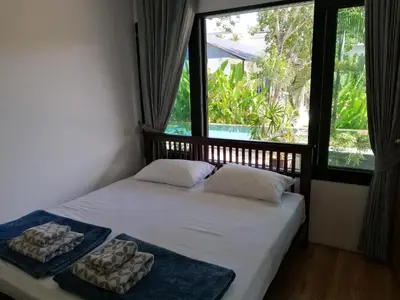 a bedroom with a bed with two pillows and a window at Twin Villa in Ban Muang Mai
