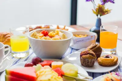 a table topped with plates of breakfast foods and orange juice at Aree Tara Ao Nang Krabi in Ao Nang Beach