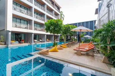 a hotel swimming pool with lounge chairs and an umbrella at Aree Tara Ao Nang Krabi in Ao Nang Beach