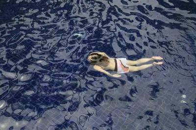 a woman swimming in the water with her dog at Sunset Beach Resort in Patong Beach