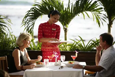a woman standing at a table with a plate of food at Sunset Beach Resort in Patong Beach