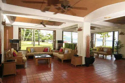 a living room with couches and tables and windows at Sunset Beach Resort in Patong Beach