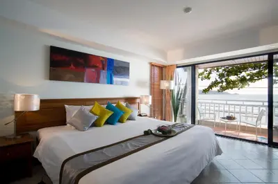a bedroom with a bed with a view of the ocean at Sunset Beach Resort in Patong Beach