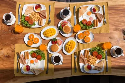 a wooden table with plates of breakfast food on it at Braya Villa in Ko Yao Yai