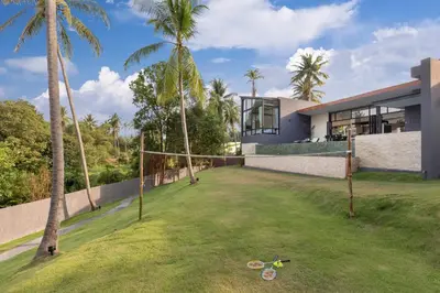 an exterior view of a house with palm trees at Braya Villa in Ko Yao Yai