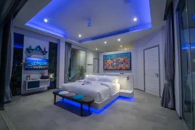 a bedroom with a large bed with a painting on the wall at Villa Enjoy Phuket in Patong Beach