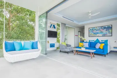 a living room with a blue couch and a table at Villa Enjoy Phuket in Patong Beach