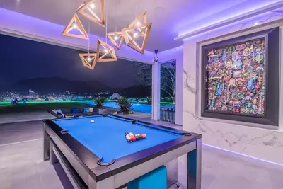 a pool table in a room with a large window at Villa Enjoy Phuket in Patong Beach