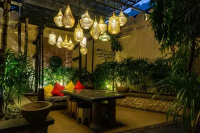 a room with a table and potted plants and lights at Sawasdee Village in Kata Beach