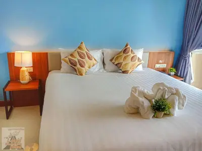 a bedroom with a bed with a stuffed animal on it at Louis' Runway View Hotel - SHA Extra Plus in Nai Yang Beach