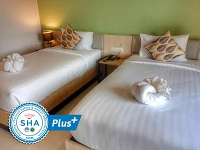 a hotel room with two beds with stuffed animals on them at Louis' Runway View Hotel - SHA Extra Plus in Nai Yang Beach
