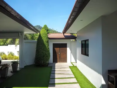 a house with a walkway leading to a door at Spacious 4 Bedrooms Private Pool Villa in Phuket in Rawai Beach