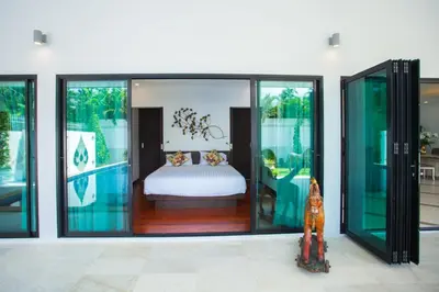 a bedroom with glass doors and a bed in it at Spacious 4 Bedrooms Private Pool Villa in Phuket in Rawai Beach