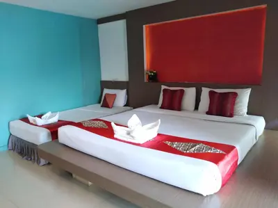 two beds in a room with red and white sheets at La Moon At Phuket - SHA Extra Plus in Phuket Town